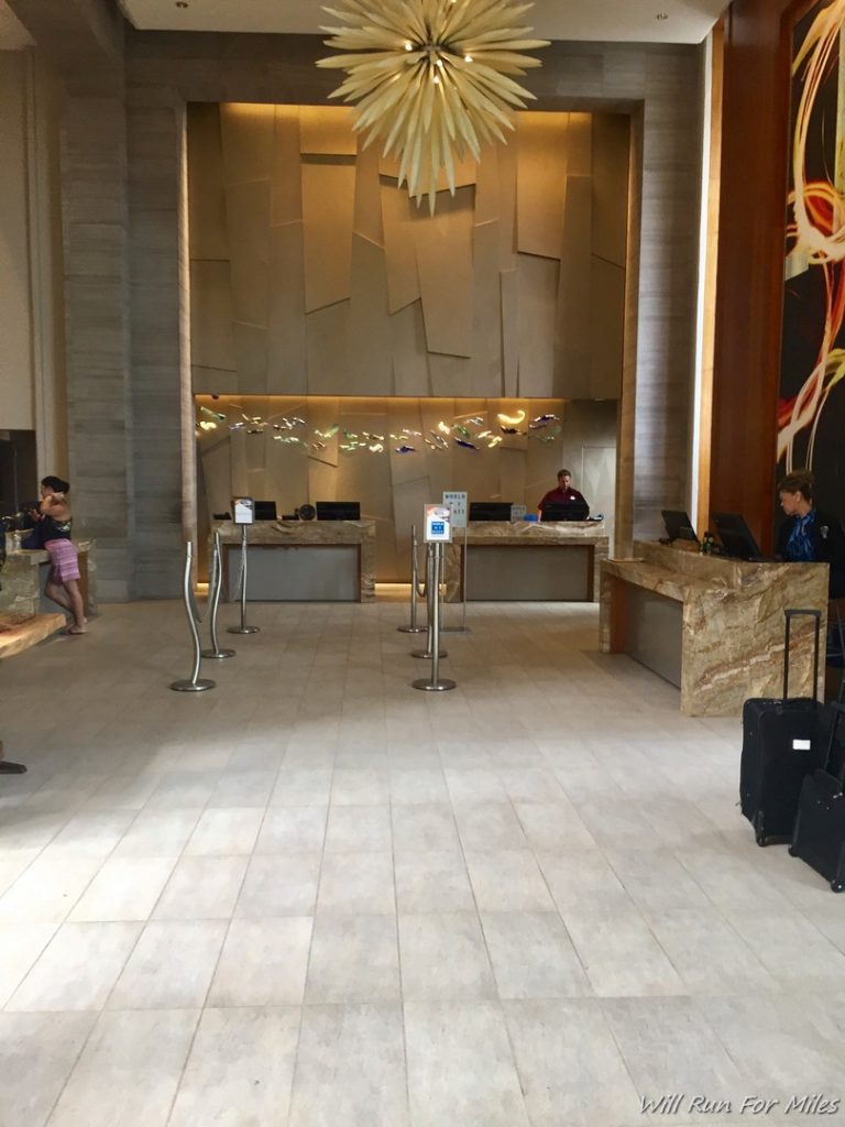 a hotel lobby with a couple of people standing in front of a counter