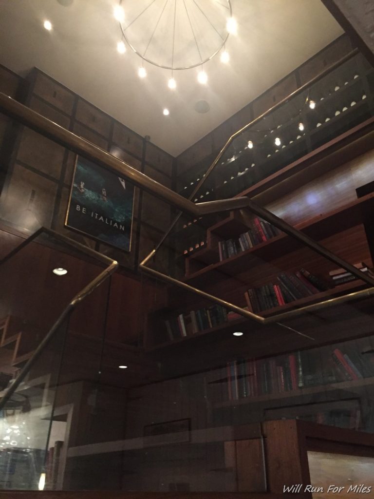 a staircase with bookshelves and a chandelier
