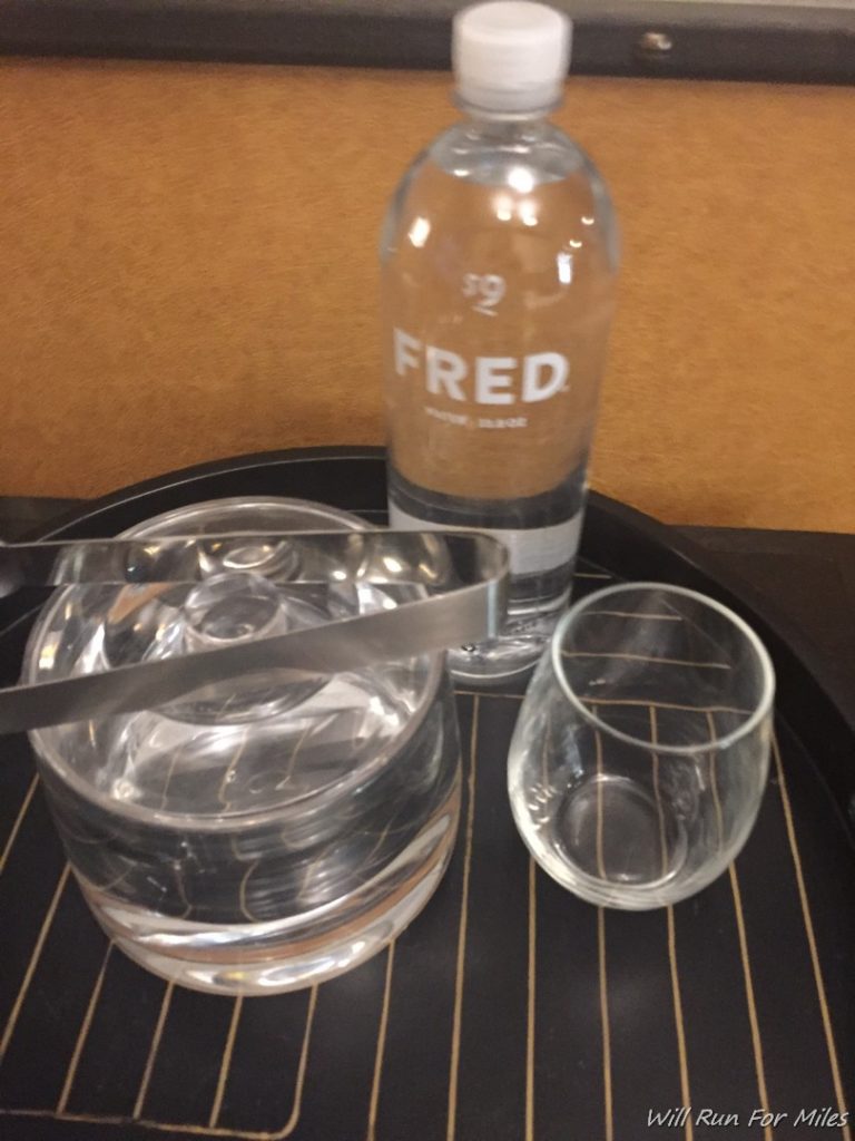 a bottle and glasses on a tray