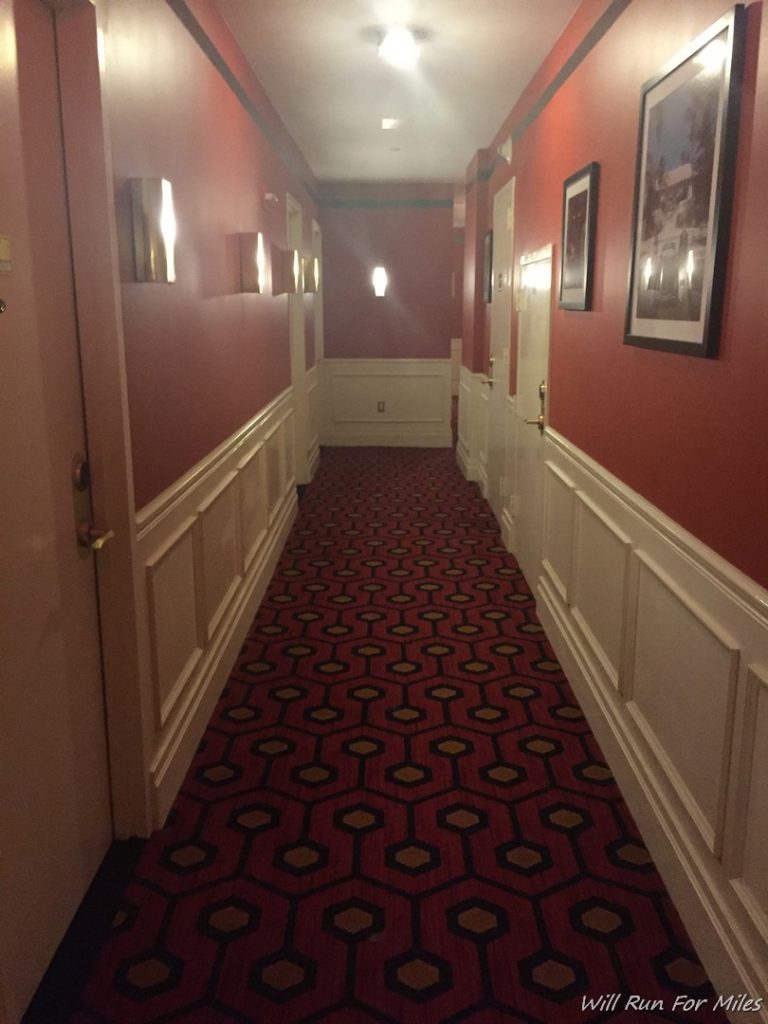 a hallway with red carpet and white walls
