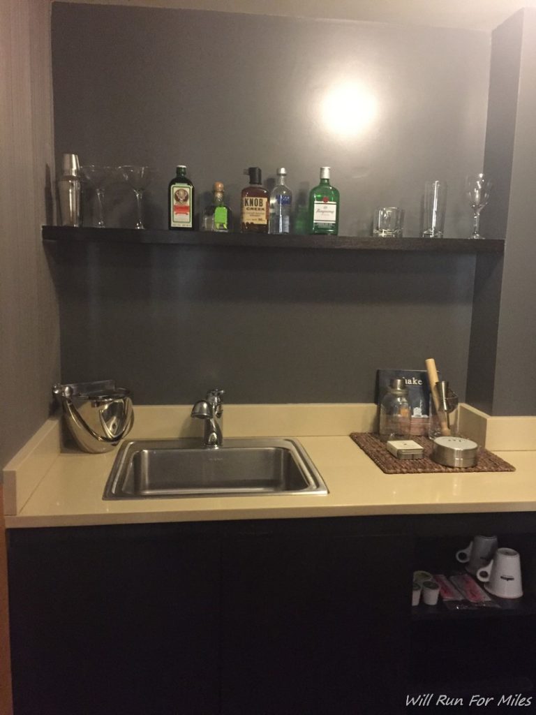 a sink and shelf with bottles on it