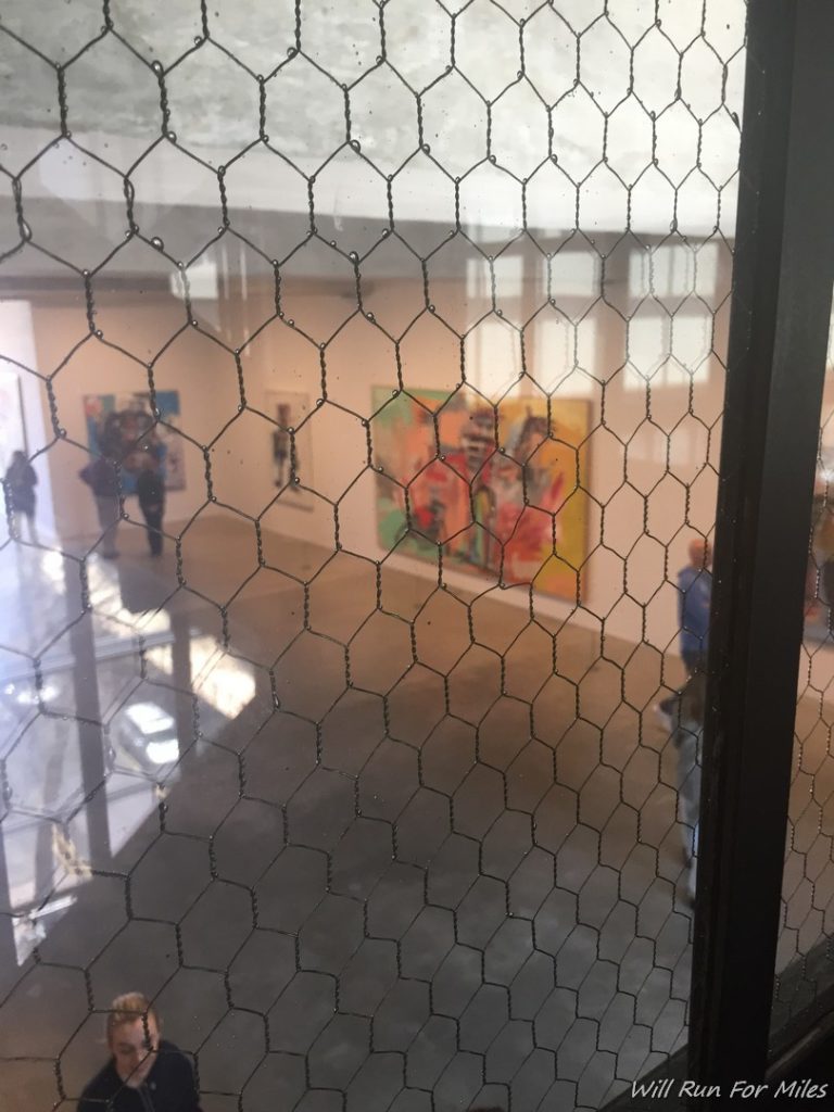 a wire mesh in a room with paintings