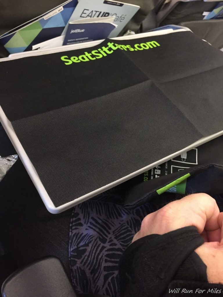 a hand holding a black and green folder