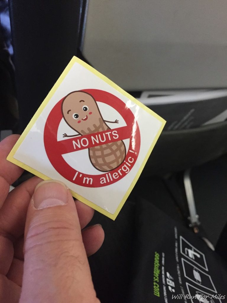 a hand holding a sticker with a cartoon peanut