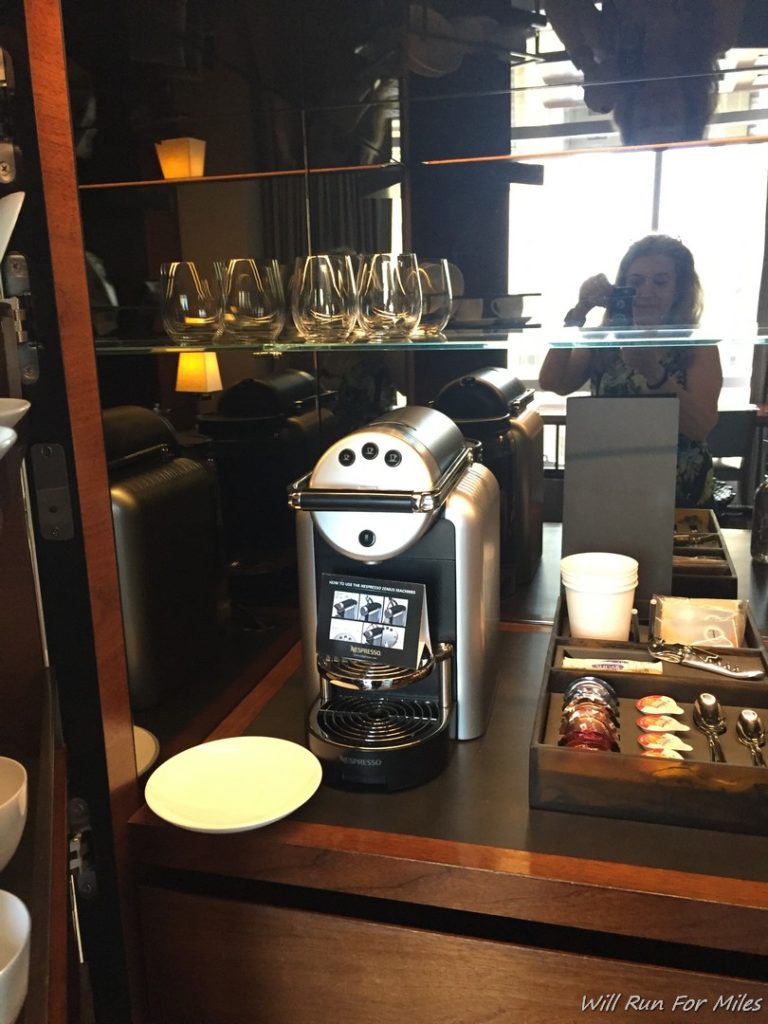 a woman taking a picture of a coffee machine