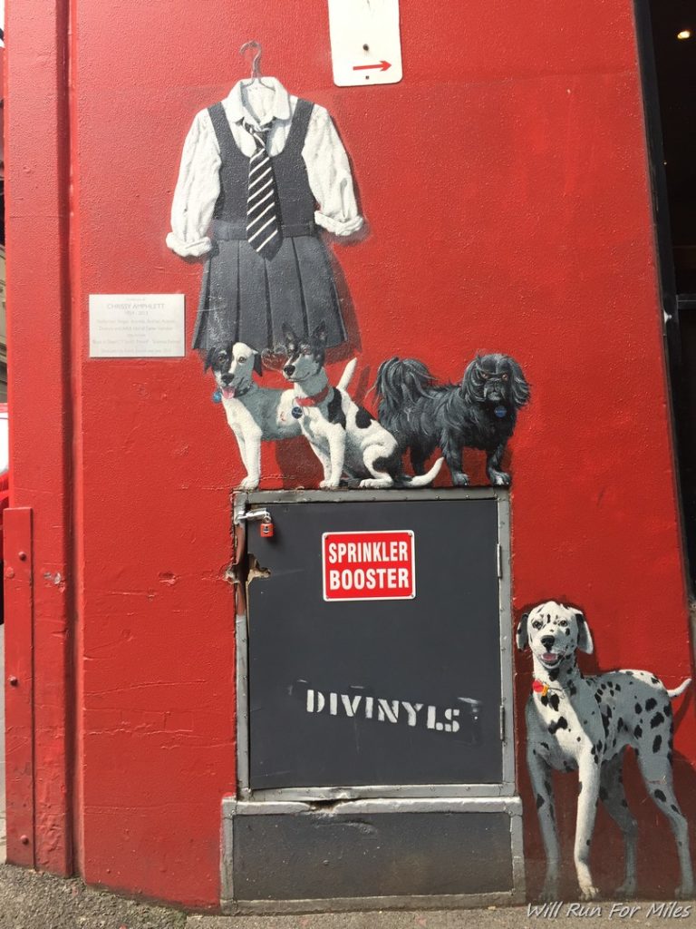a painting of dogs on a red wall