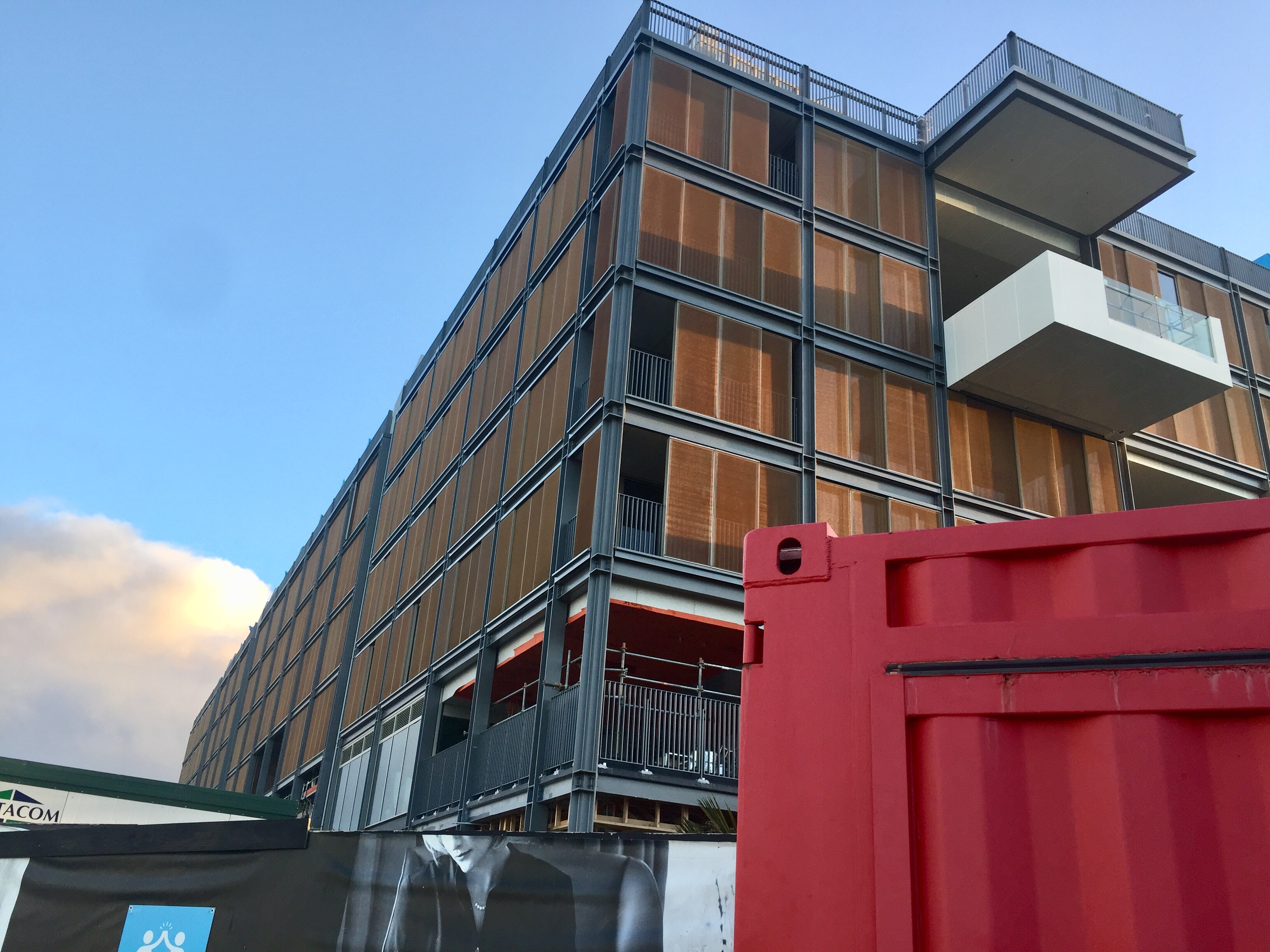 a building with balconies and a red container