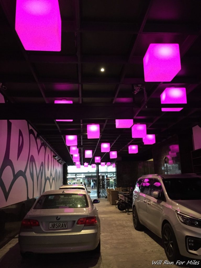 a row of cars with pink lights