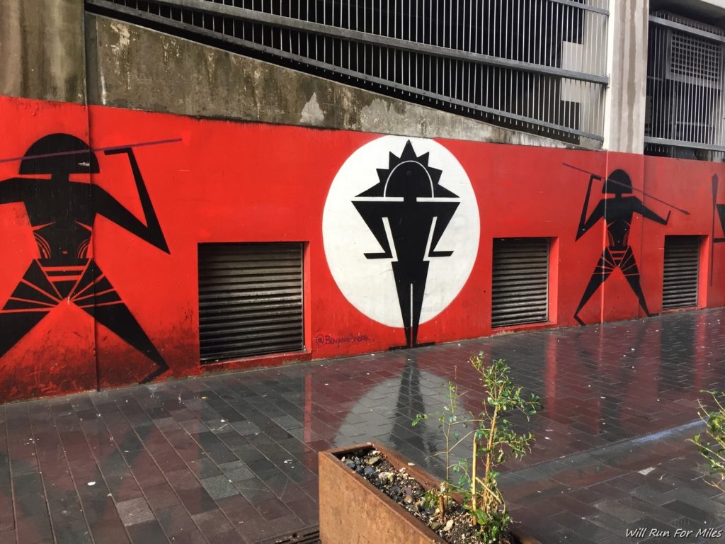 a red wall with black and white figures on it