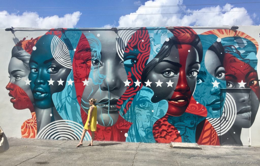 a woman standing in front of a mural