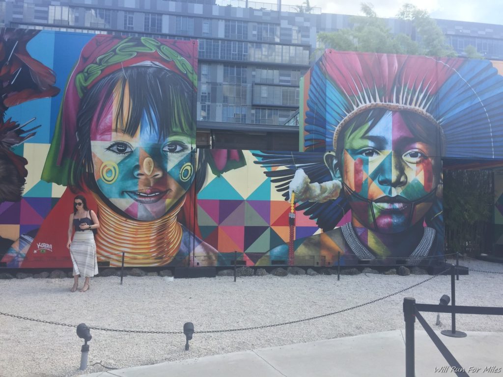 a woman standing in front of a mural of a woman