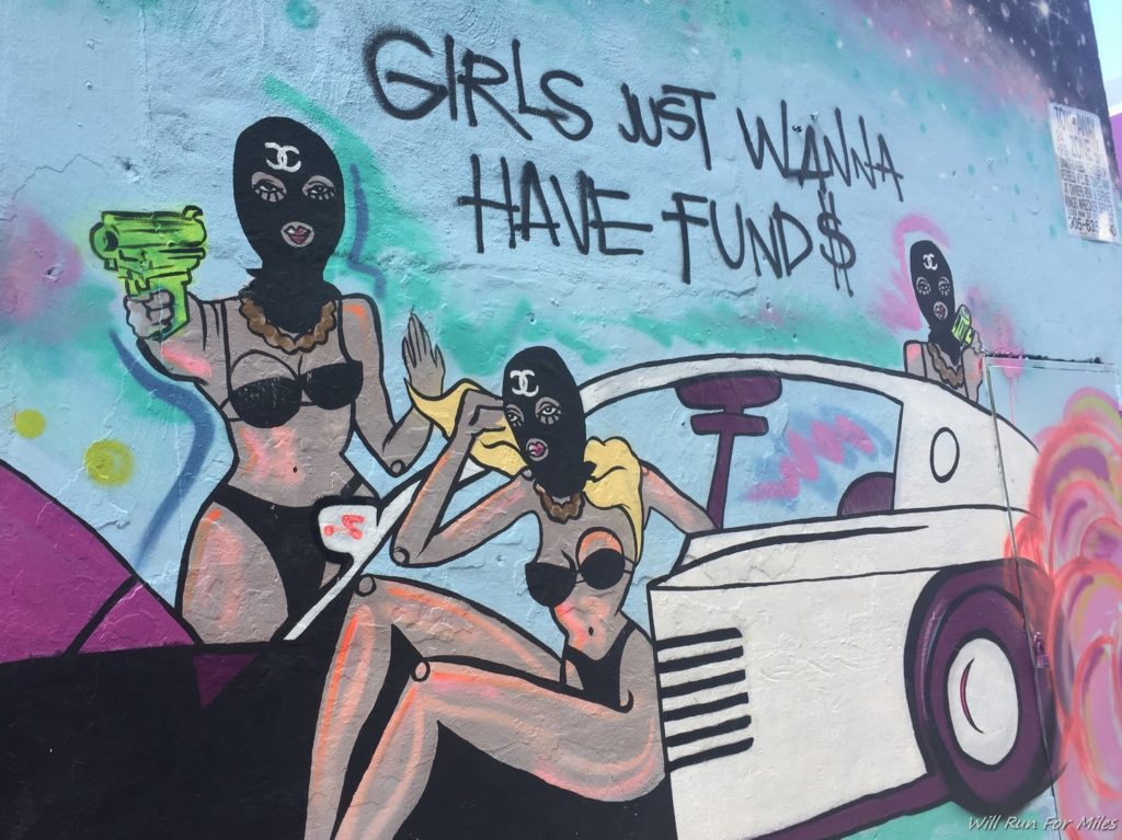 a mural of women in garments and a car