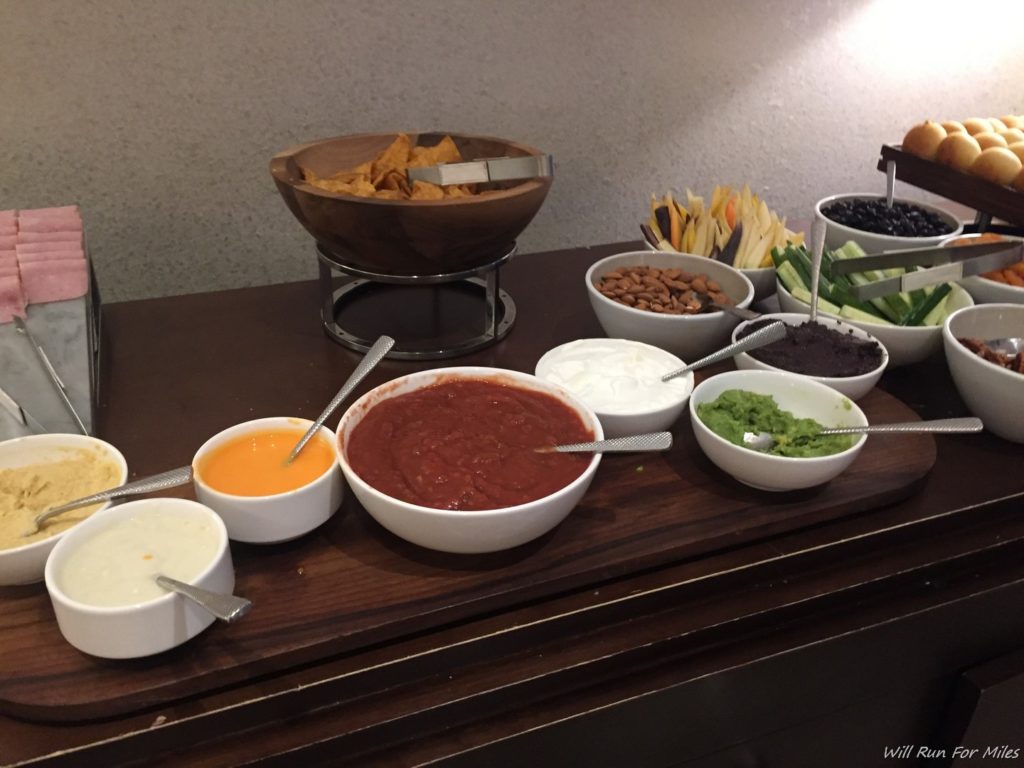 a table with bowls of dips and bowls of food