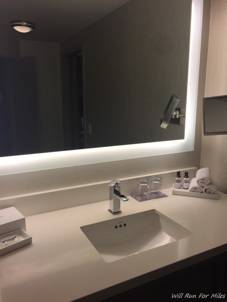 a bathroom sink with a lighted mirror