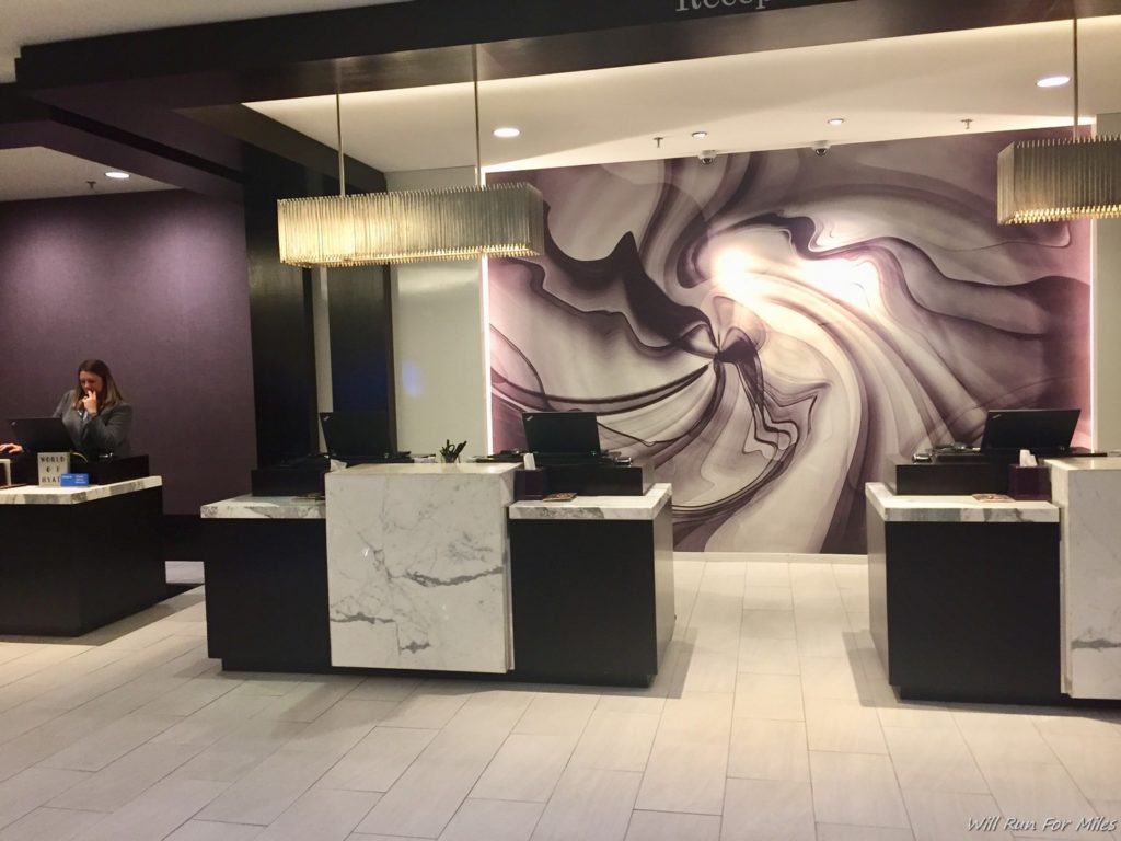 a reception area with a marble counter and a marble wall