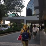 a woman walking down a sidewalk with a backpack