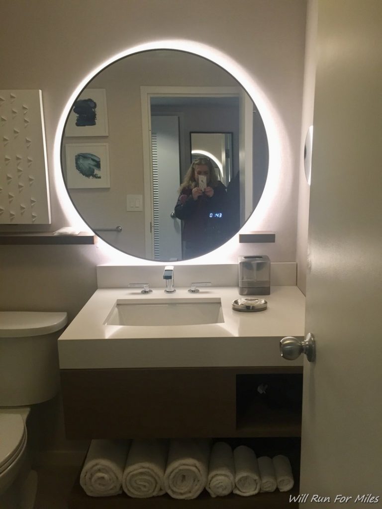 a woman taking a selfie in a bathroom mirror