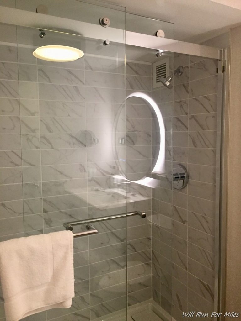 a glass shower with a towel on a rack