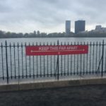 a sign on a fence by water