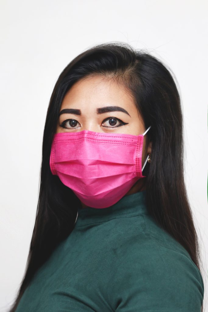 a woman wearing a pink face mask