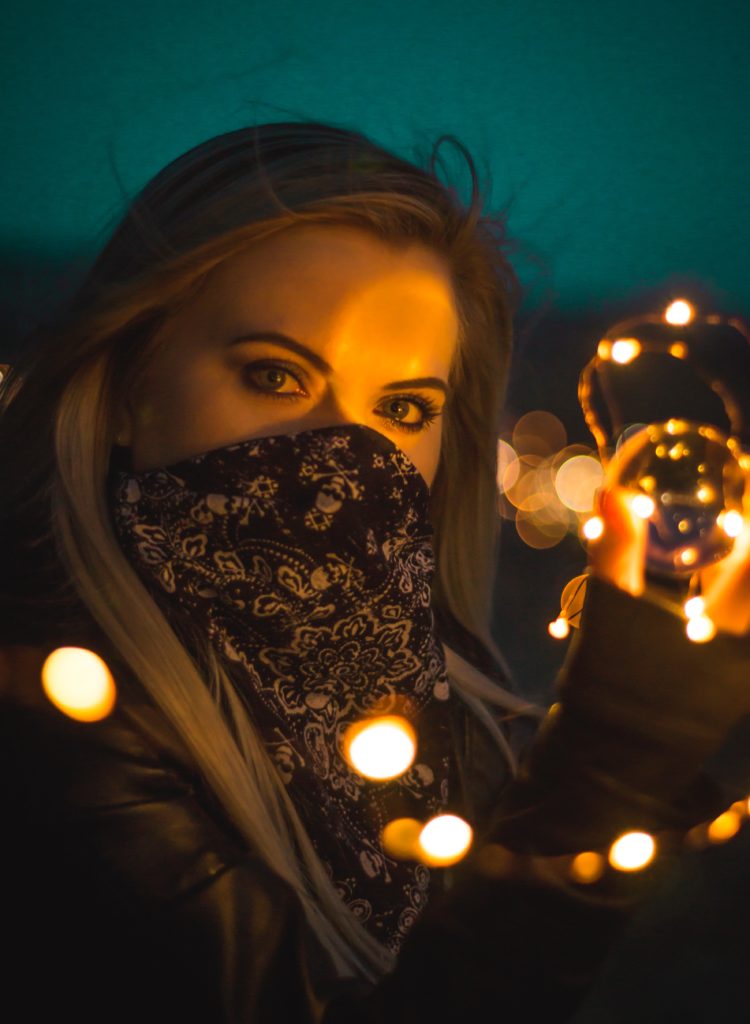 a woman holding a string of lights