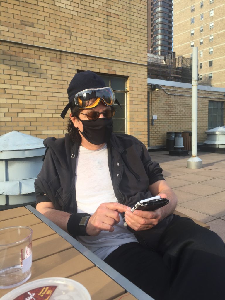 a man wearing goggles and a mask sitting outside