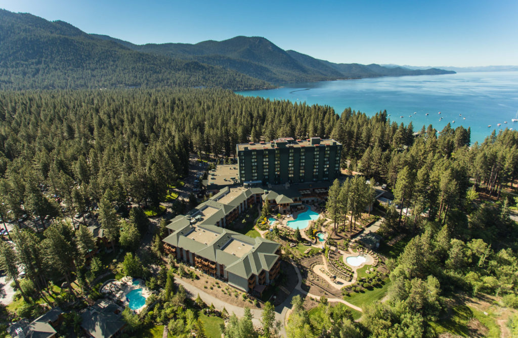 a hotel surrounded by trees and a body of water