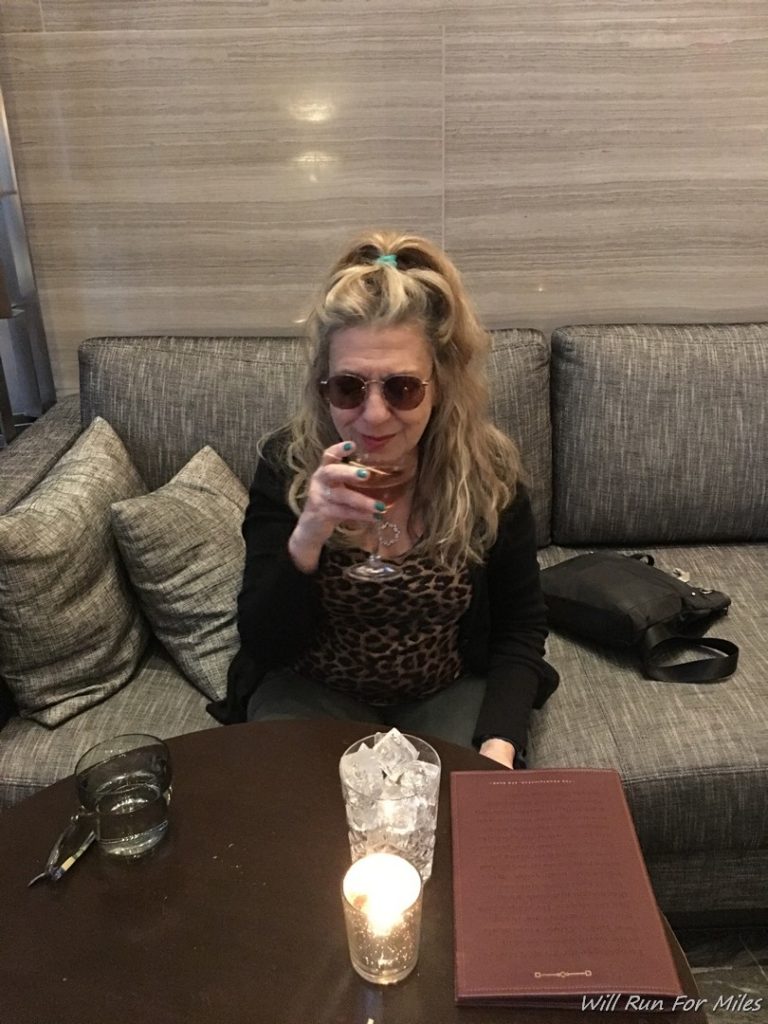a woman sitting on a couch holding a glass of wine