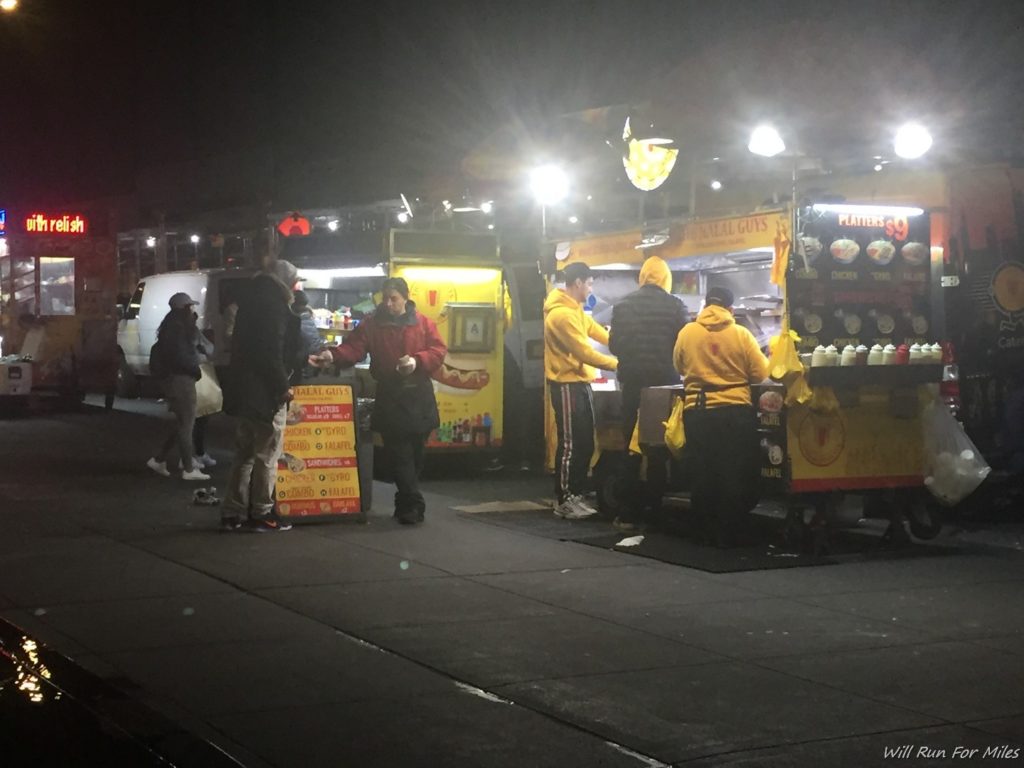 a group of people standing in front of food trucks
