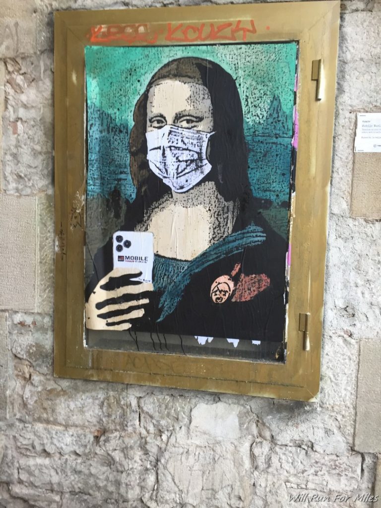 a painting of a woman wearing a face mask on a wall