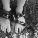 a person's feet tied with a chain