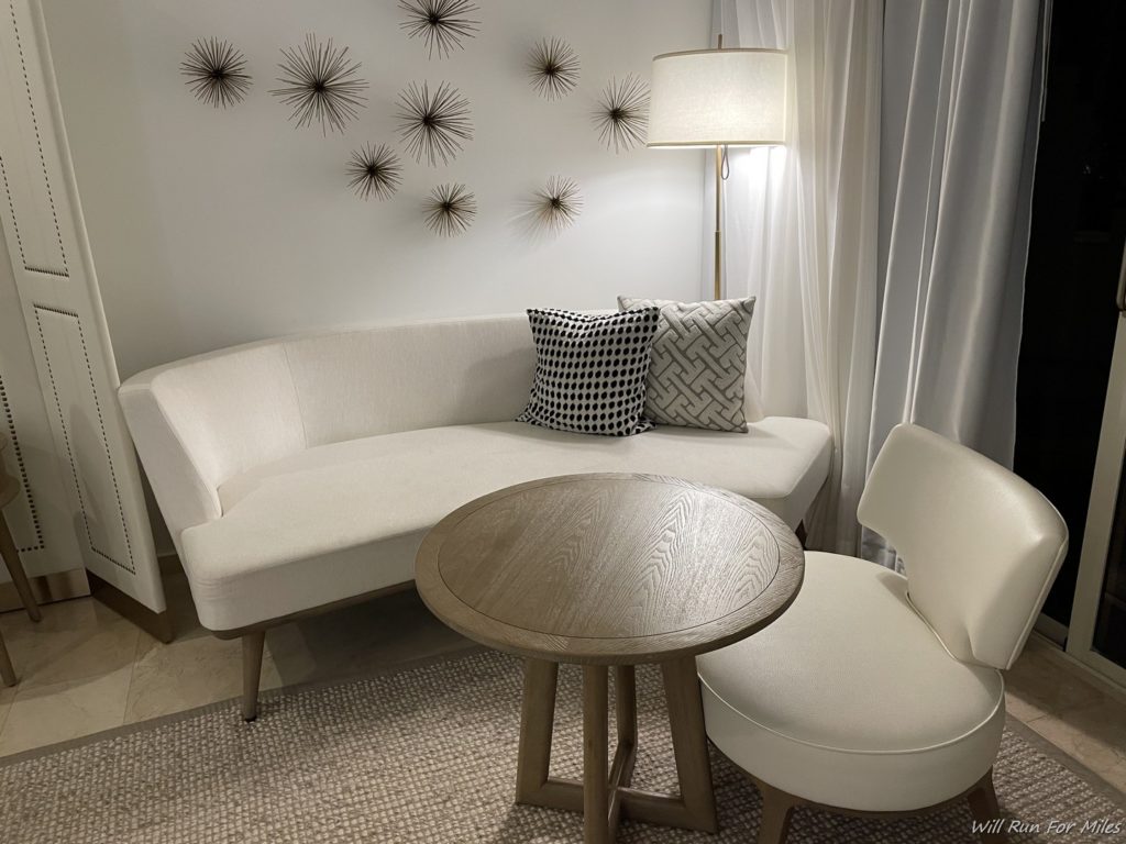 a white couch with pillows and a round table