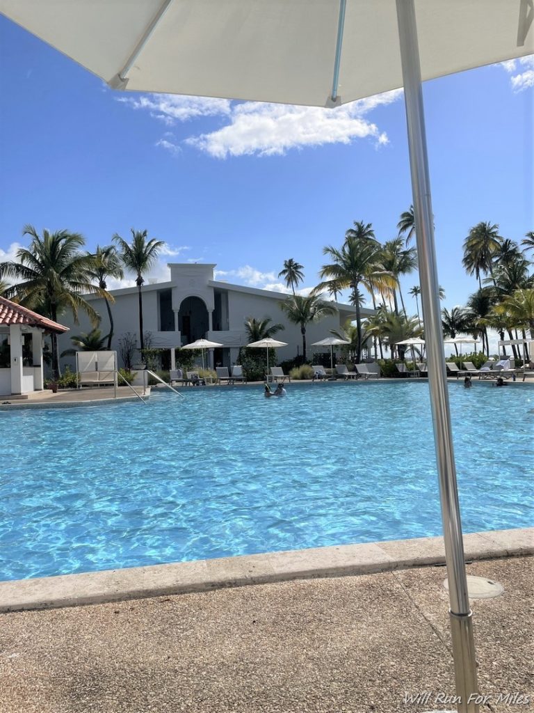 a pool with a building and palm trees