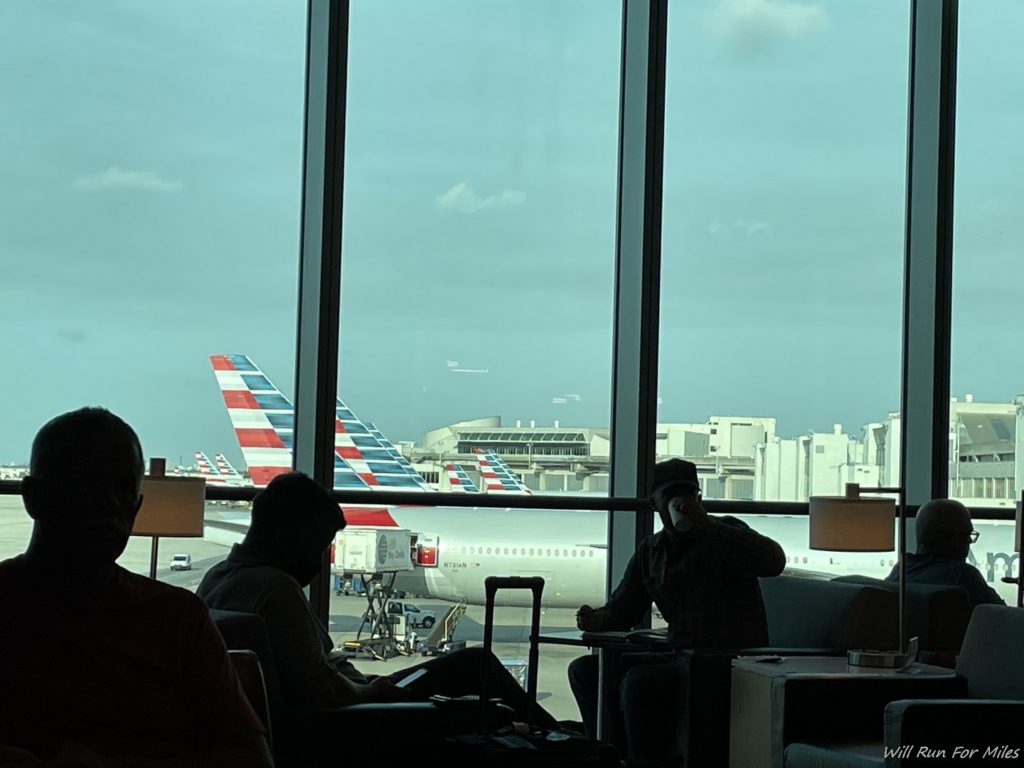 people sitting in a lounge with a plane in the background
