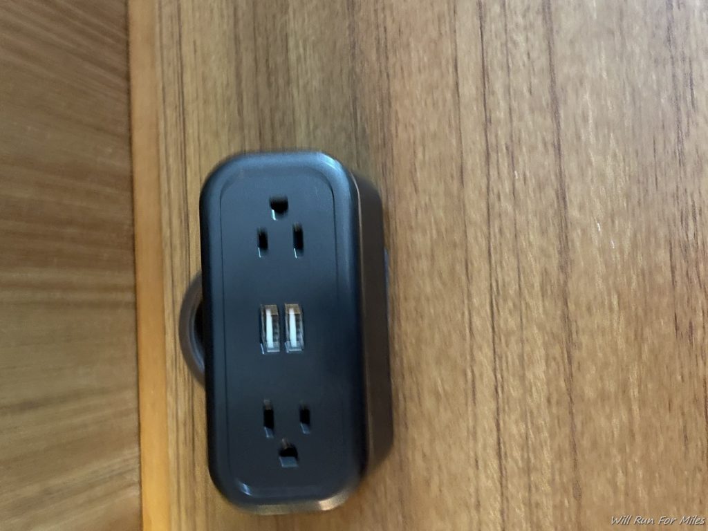 a black power outlet on a wood surface