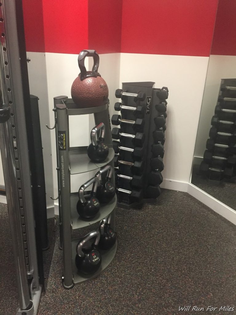 a rack of kettlebells and weights