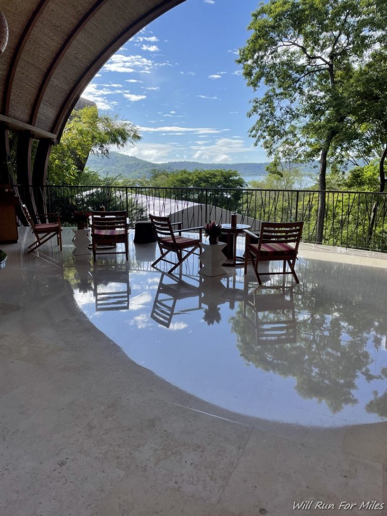 a patio with chairs and tables on a reflective surface