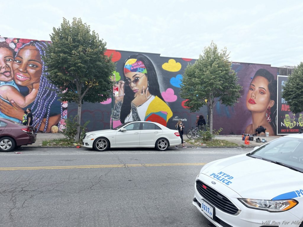 a mural of women and cars on a street