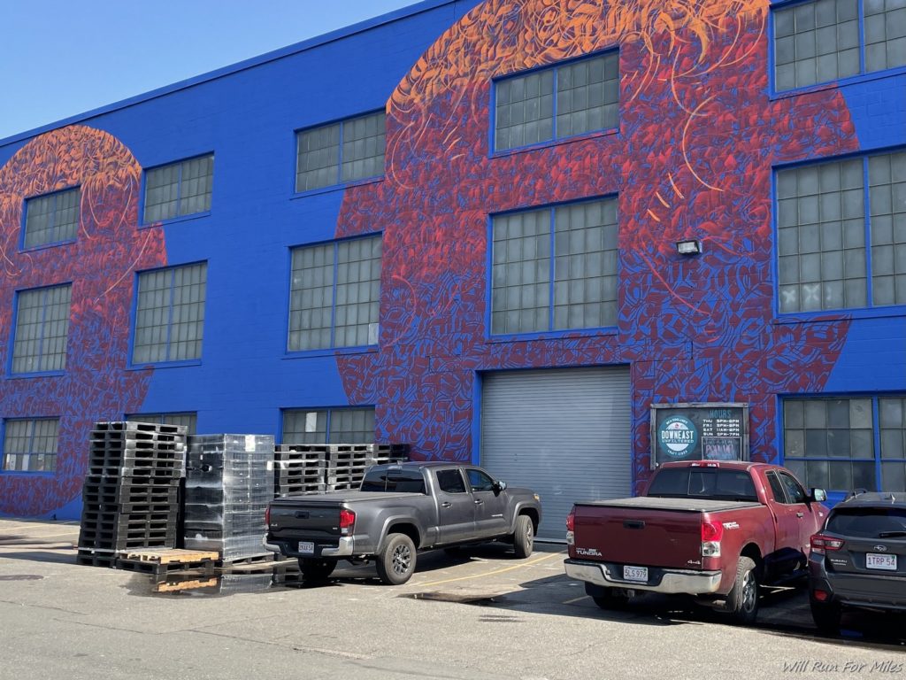 a blue building with a painted wall and a couple of trucks