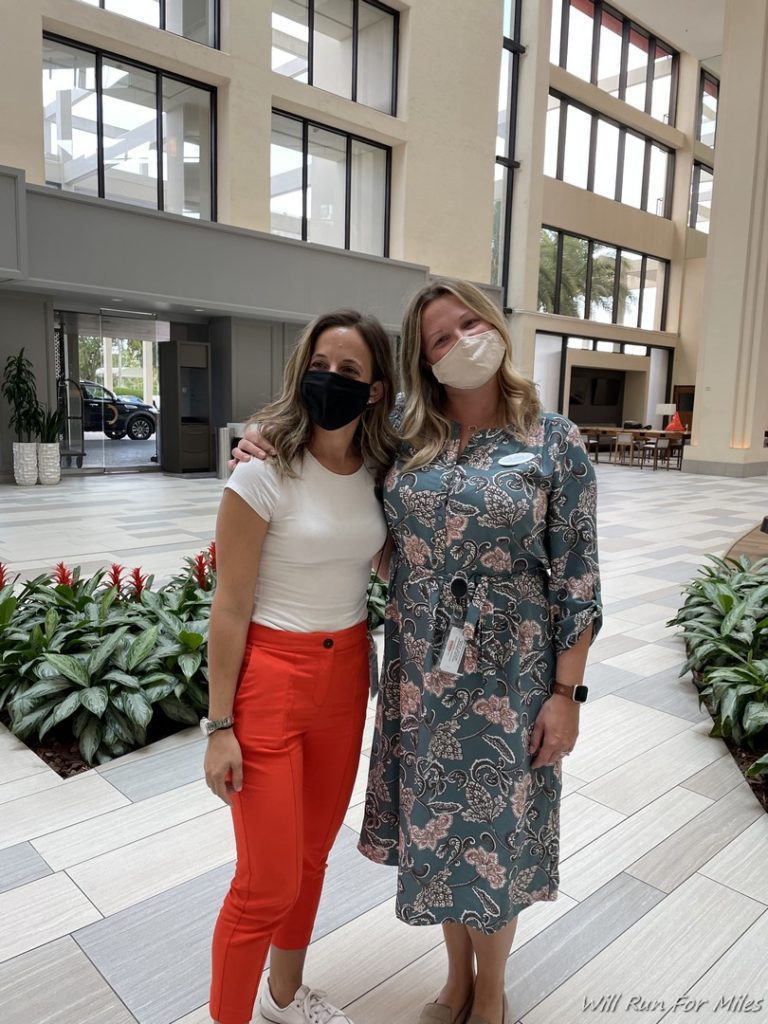 two women wearing face masks in a building