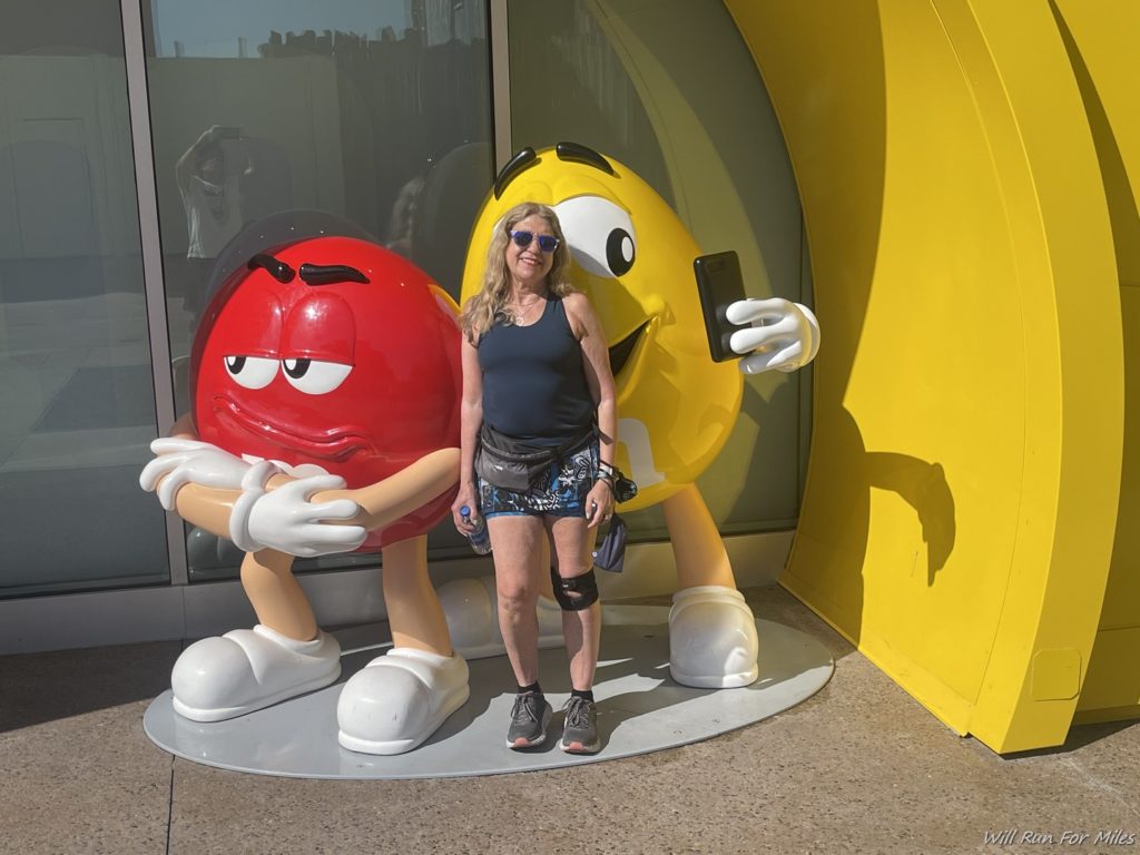 a woman standing next to a statue of a cartoon character