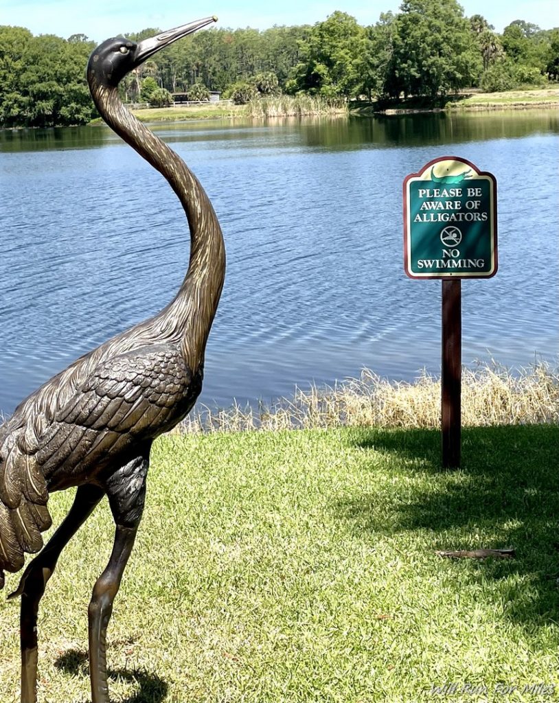 a statue of a bird next to a lake