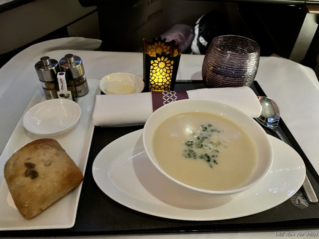 a plate of soup and bread on a tray