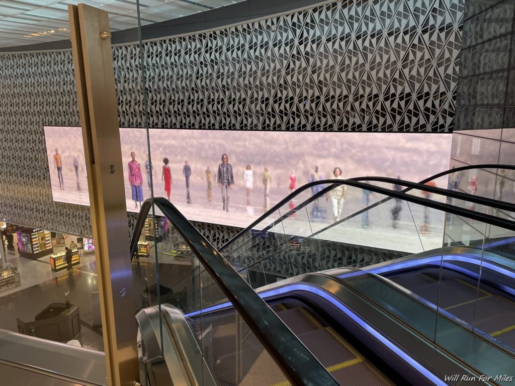 escalators in a building with people walking on the wall