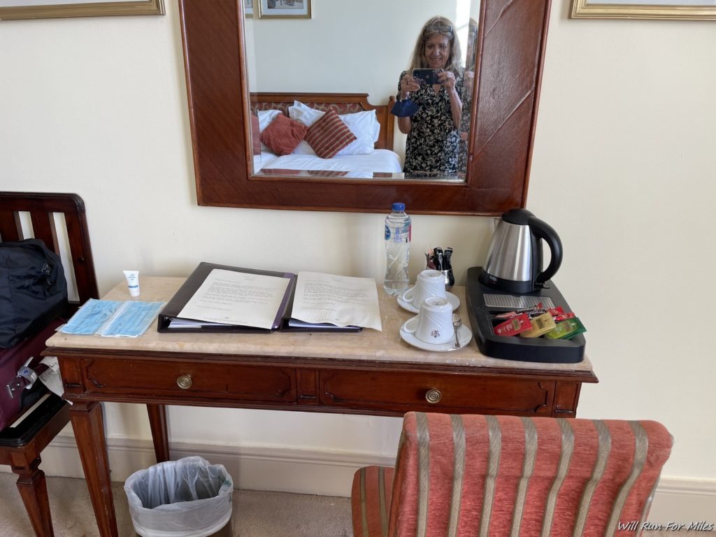 a mirror of a woman taking a selfie in a hotel room