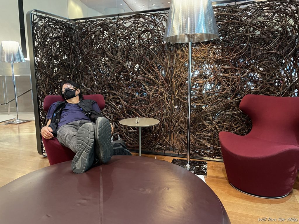 a man lying on a chair in a room with vines