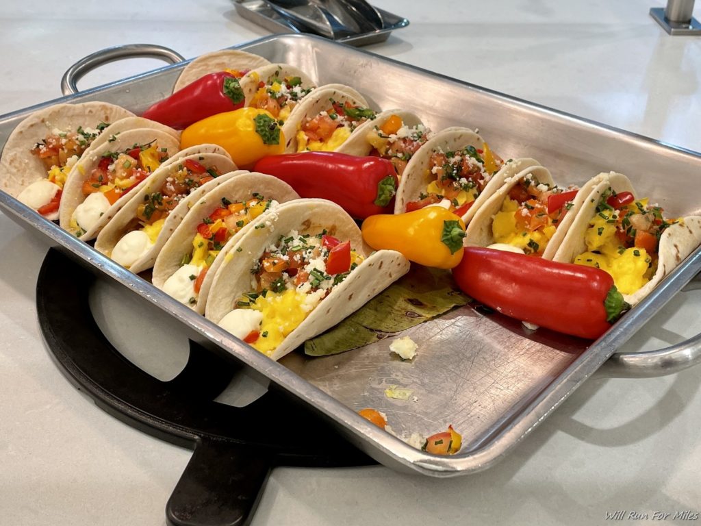 a tray of tacos with peppers on it