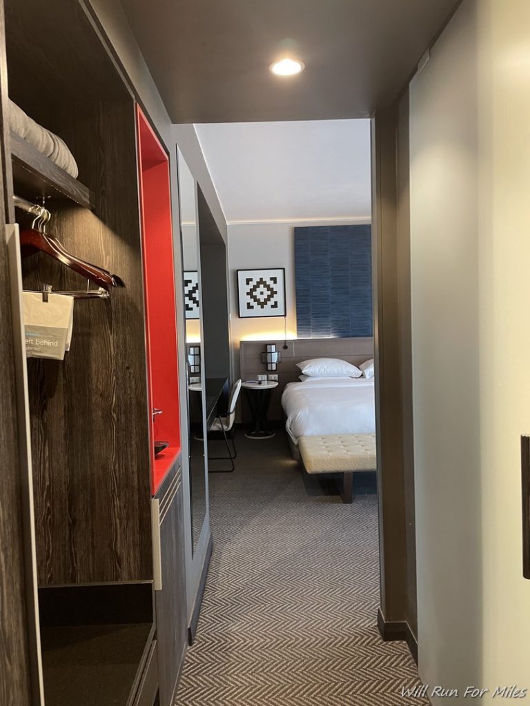 a hallway with a bed and a mirror