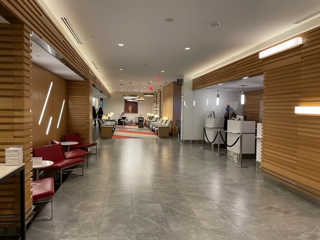 a lobby with a couple of chairs and a man standing in front of it