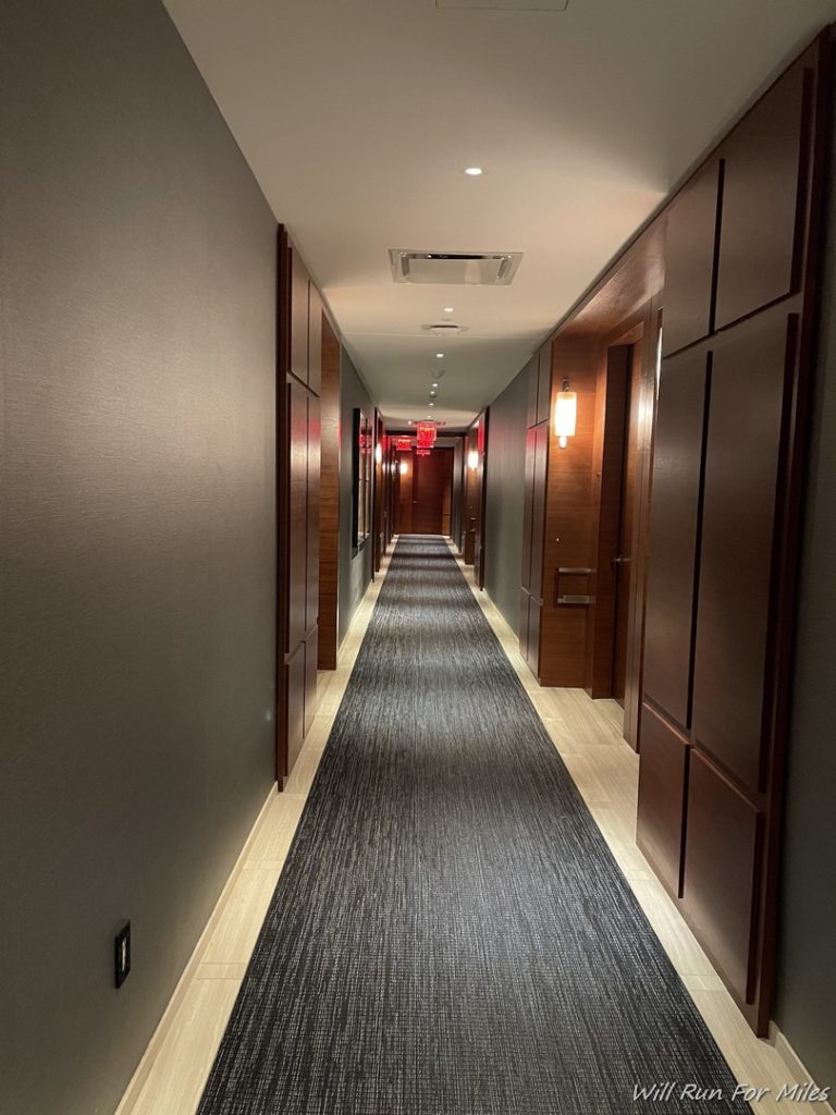 a long hallway with doors and a carpet